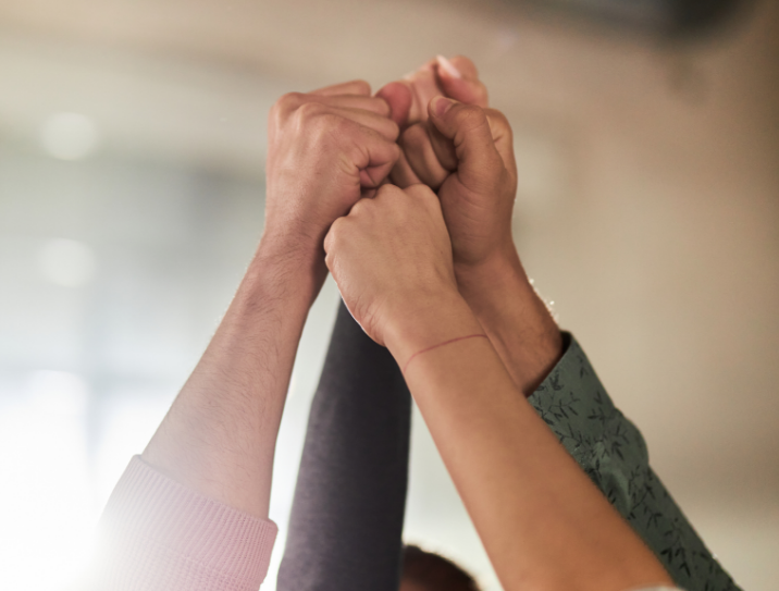 Mãos de várias pessoas unidas no alto